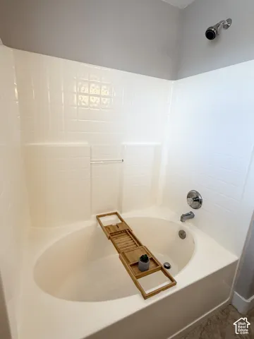 Built-in soaking tub with chrome fixtures and white tiled surround