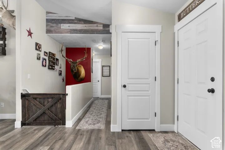 Wood-finish flooring throughout, white paneled doors, and a decorative wooden gate