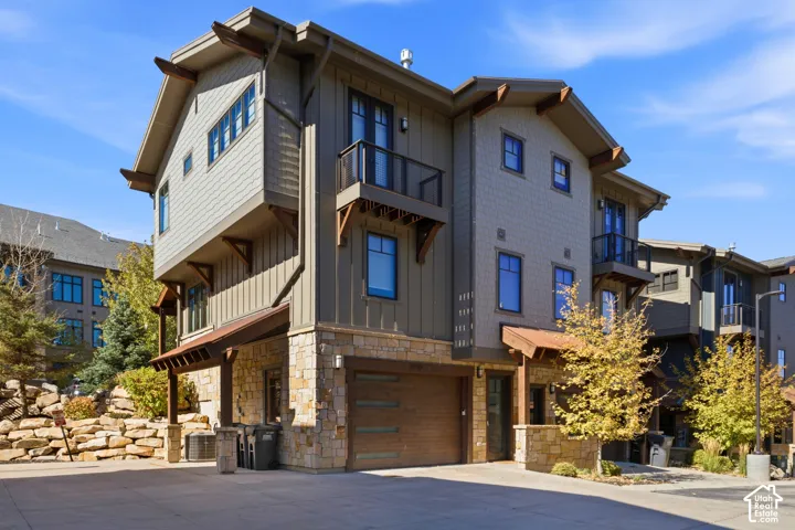 Multi-level exterior featuring stone accents, wood siding, and multiple balconies