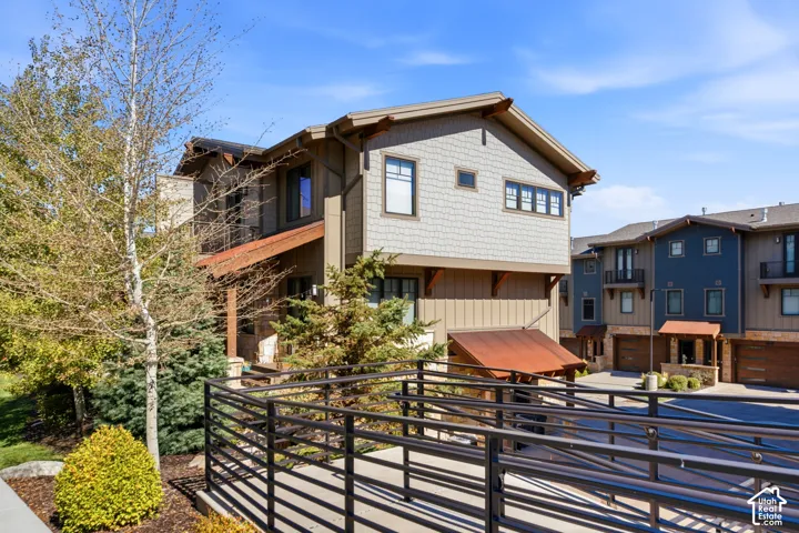 Multi-story exterior featuring a mix of vertical siding and shake siding, complemented by a covered entry with a metal roof