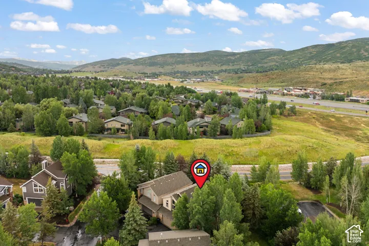 Aerial perspective showcasing a residential area with varied rooflines and surrounding natural landscapes