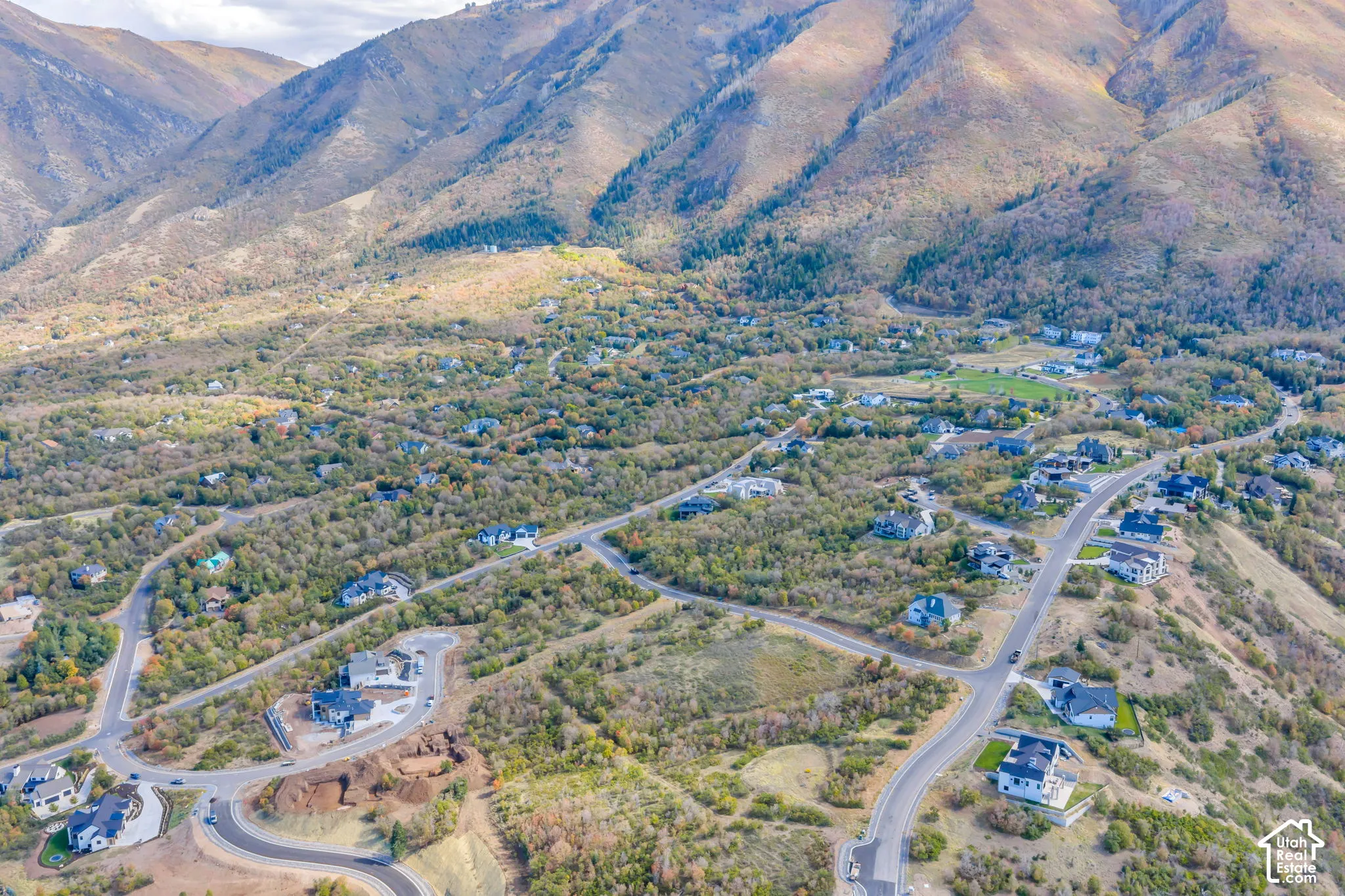 Mountainous landscape surrounding a residential area with varied housing styles and paved roads