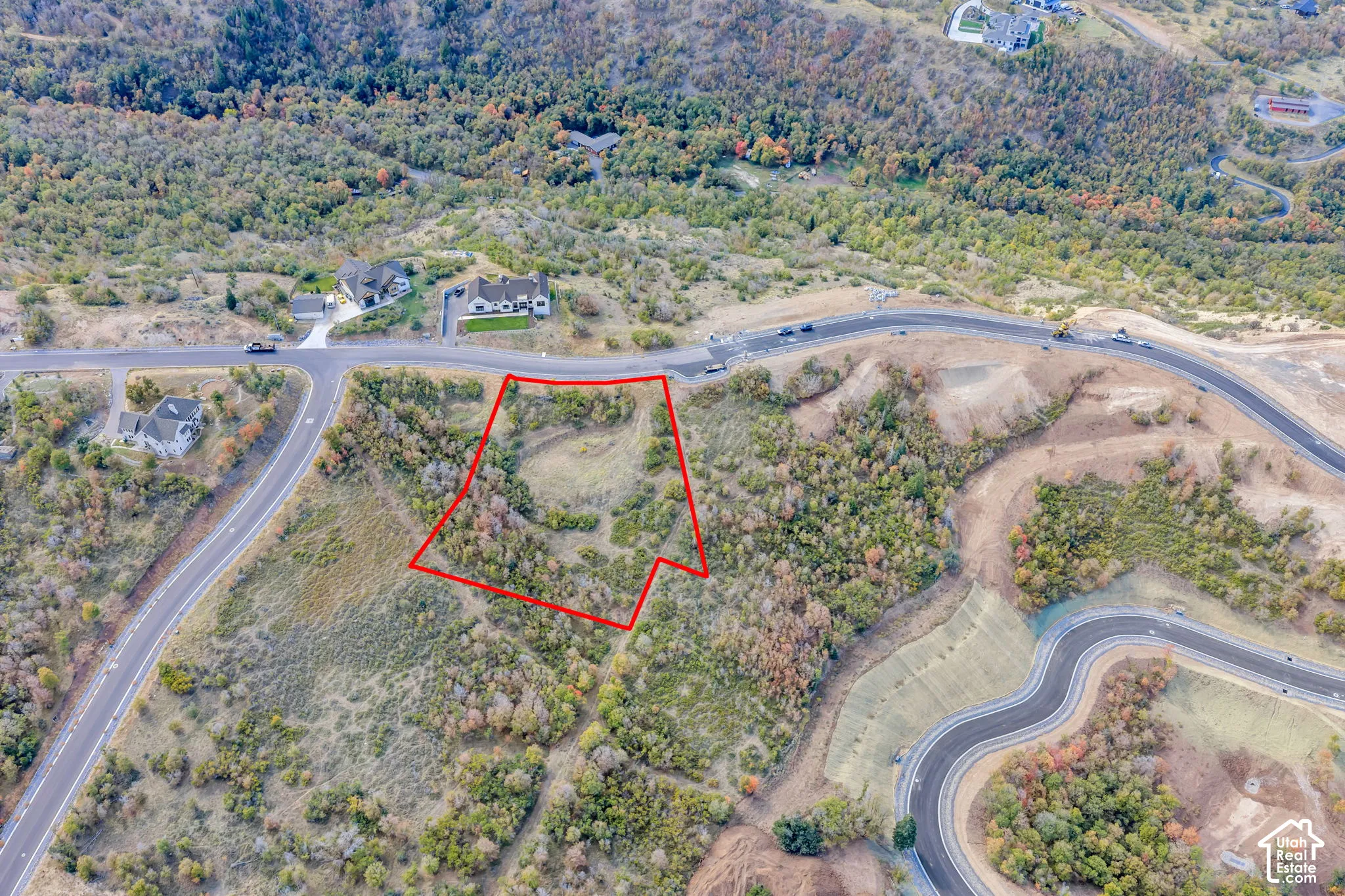 Expansive undeveloped land parcel bordered by paved roads and natural vegetation