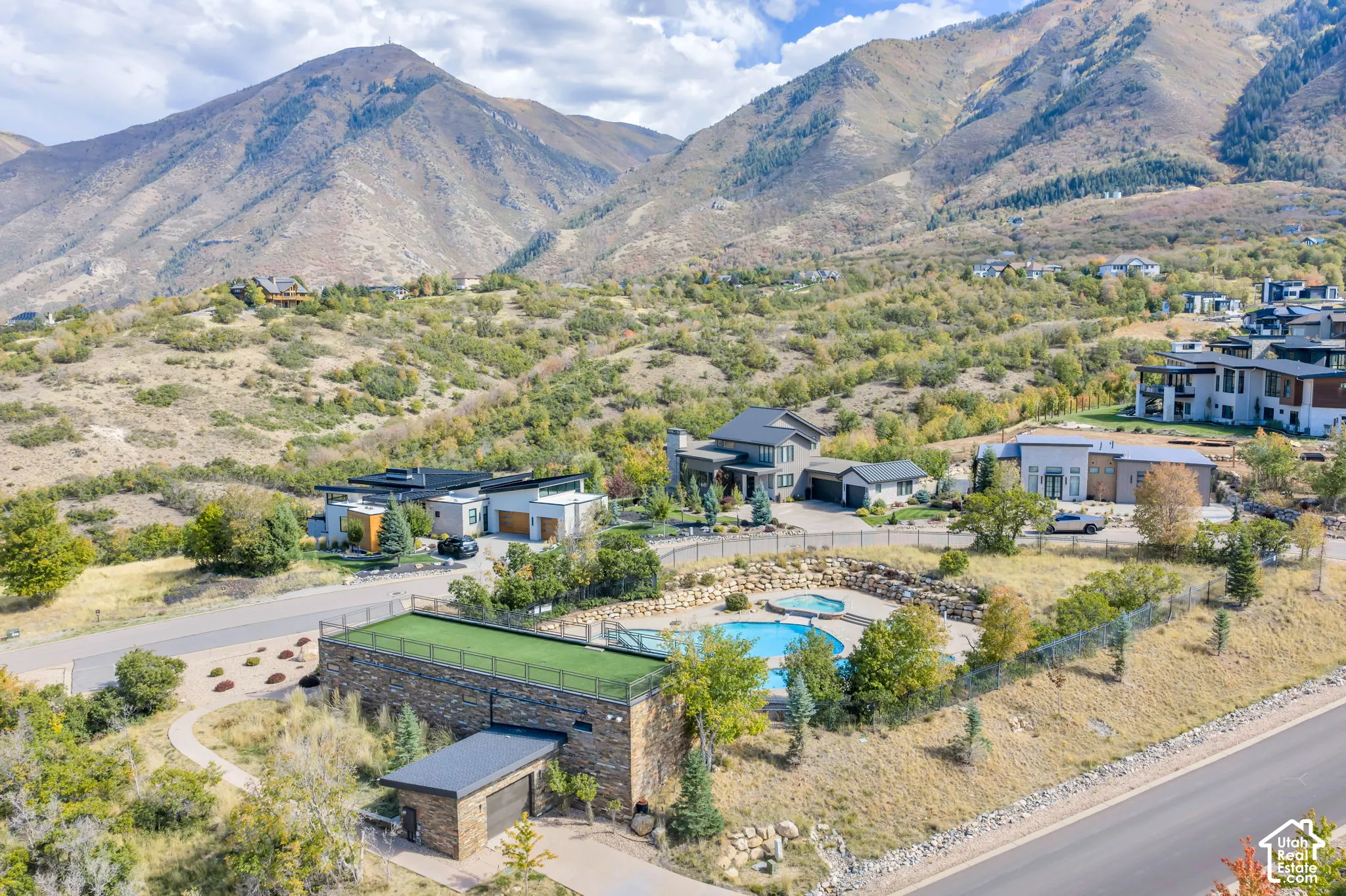 Expansive property featuring a swimming pool, a hot tub, and a surrounding paved patio