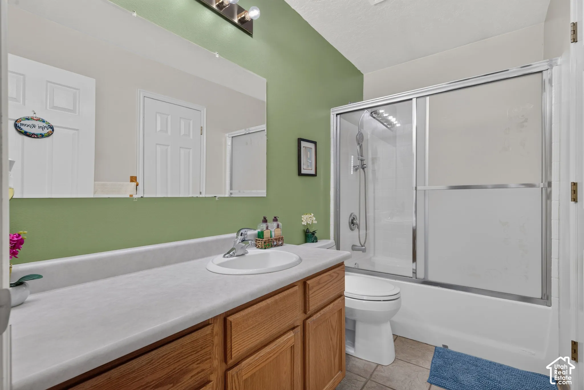 Single vanity with a white countertop and wood-finish cabinetry