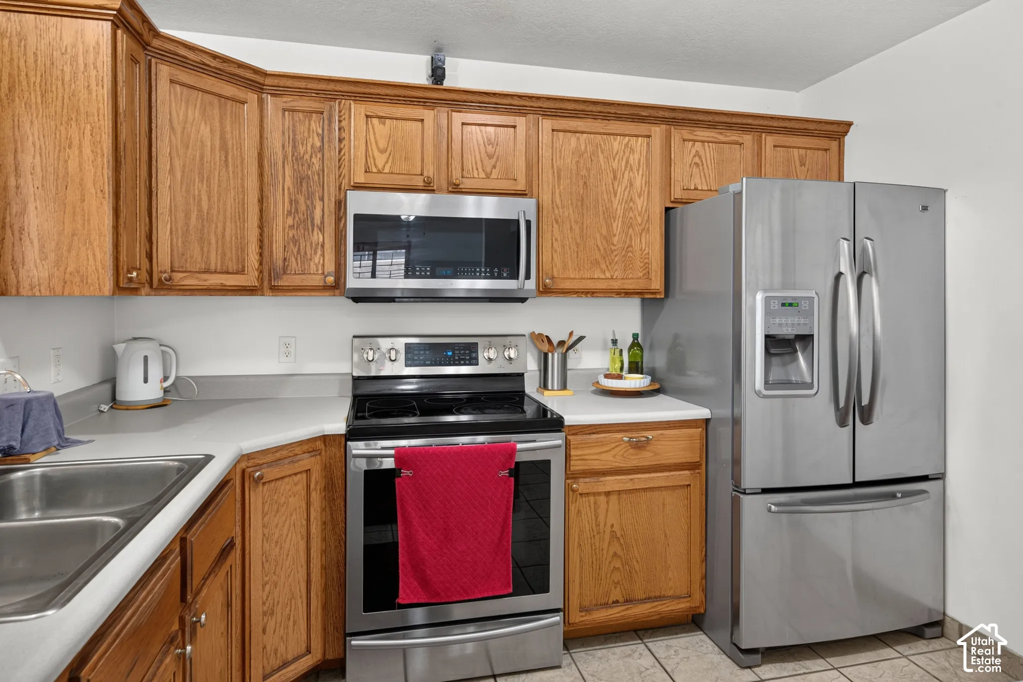 Hardwood cabinetry, stainless steel appliances, dual basin sink, and ample countertop space