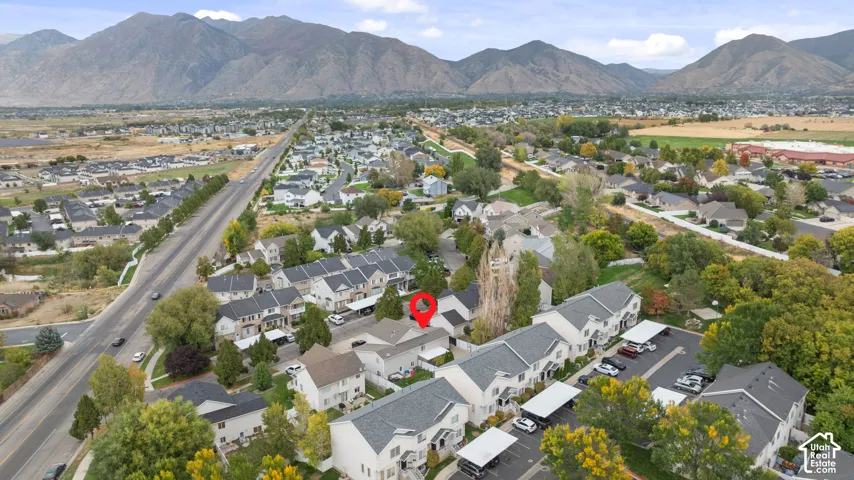 Residential community with mountain backdrop, multi-unit properties, and paved surface parking