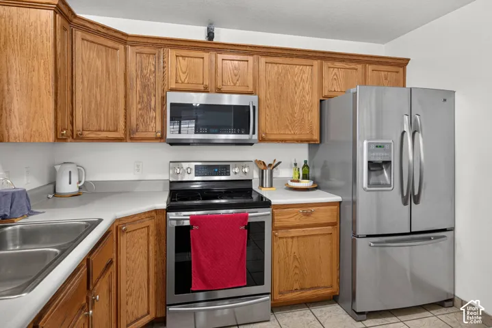 Hardwood cabinetry, stainless steel appliances, dual basin sink, and ample countertop space