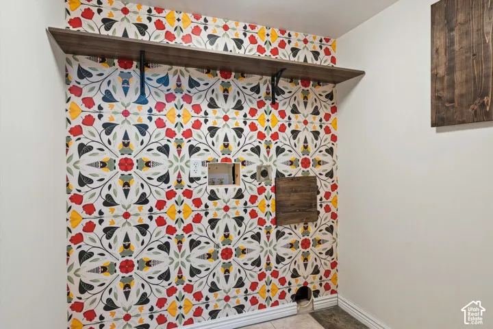 Wallpapered accent wall with a floral pattern, featuring a wood-finish floating shelf