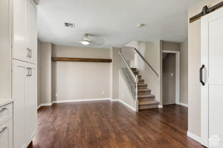 Wood-finish flooring throughout, white shaker-style cabinetry, and a ceiling fan with integrated lighting