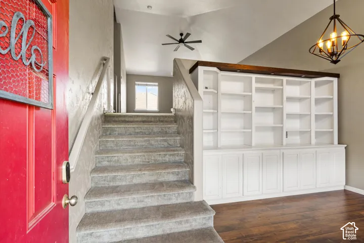 Vaulted ceiling, wood-finish flooring, built-in shelving, chandelier, ceiling fan