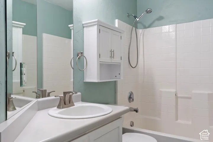 Vanity with integrated sink, brushed nickel faucet, wall-mounted storage cabinet, and full-width mirror