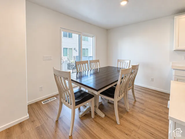 Recessed lighting, wood-finish flooring, white walls, and a sliding glass door