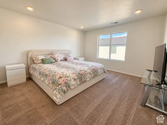 Recessed ceiling lighting, broad window, and plush carpeting