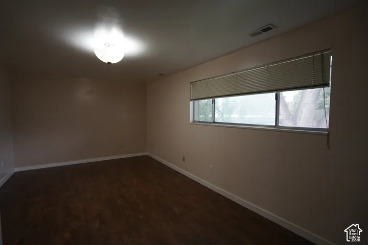Wood-finish flooring with neutral wall tones and a ceiling-mounted light fixture