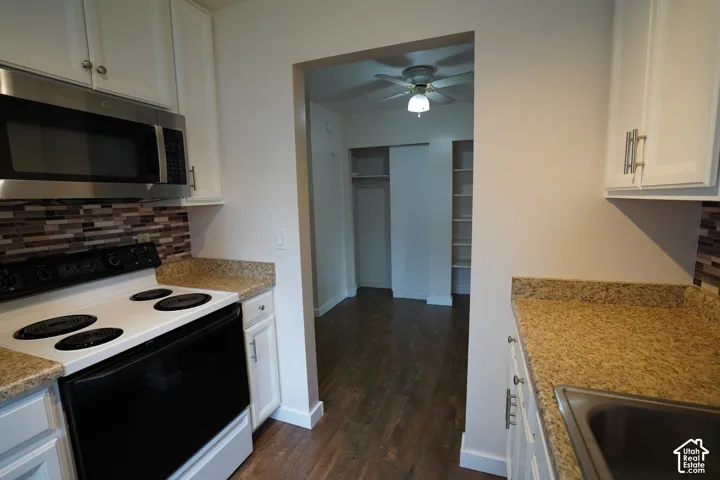 Kitchen featuring white cabinetry, a stainless steel microwave, and granite-look countertops