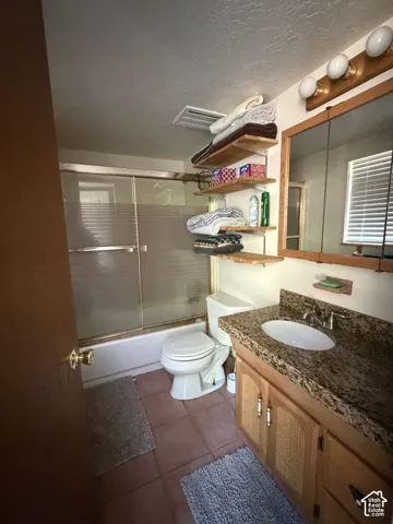 Bathroom featuring a vanity with a stone countertop, an integrated sink, and wood cabinetry