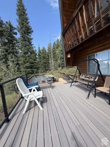 Expansive outdoor deck with composite decking, cable railing, and a log-style exterior