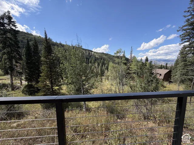Cable railing system overlooking a wooded hillside with distant structures