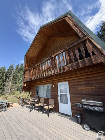 Wood-sided exterior with an upper-level balcony featuring a wood railing