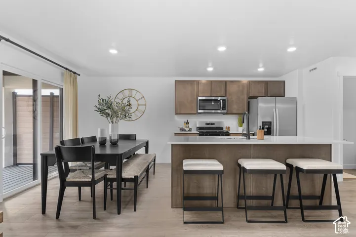 Open-concept living area featuring wood-finish flooring, recessed lighting, and a sliding glass door
