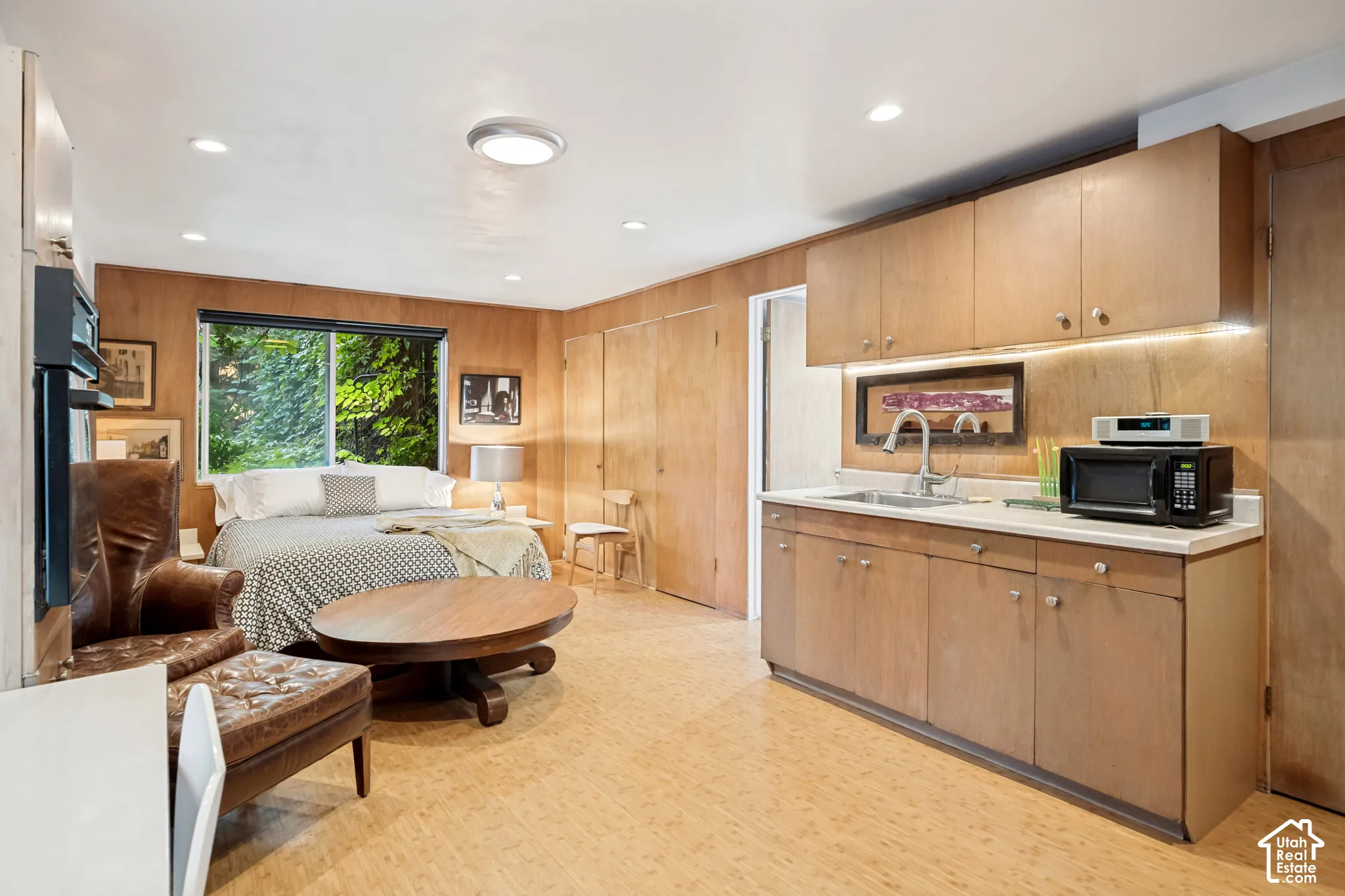 Integrated kitchenette featuring wood-finish cabinetry and a stainless steel sink