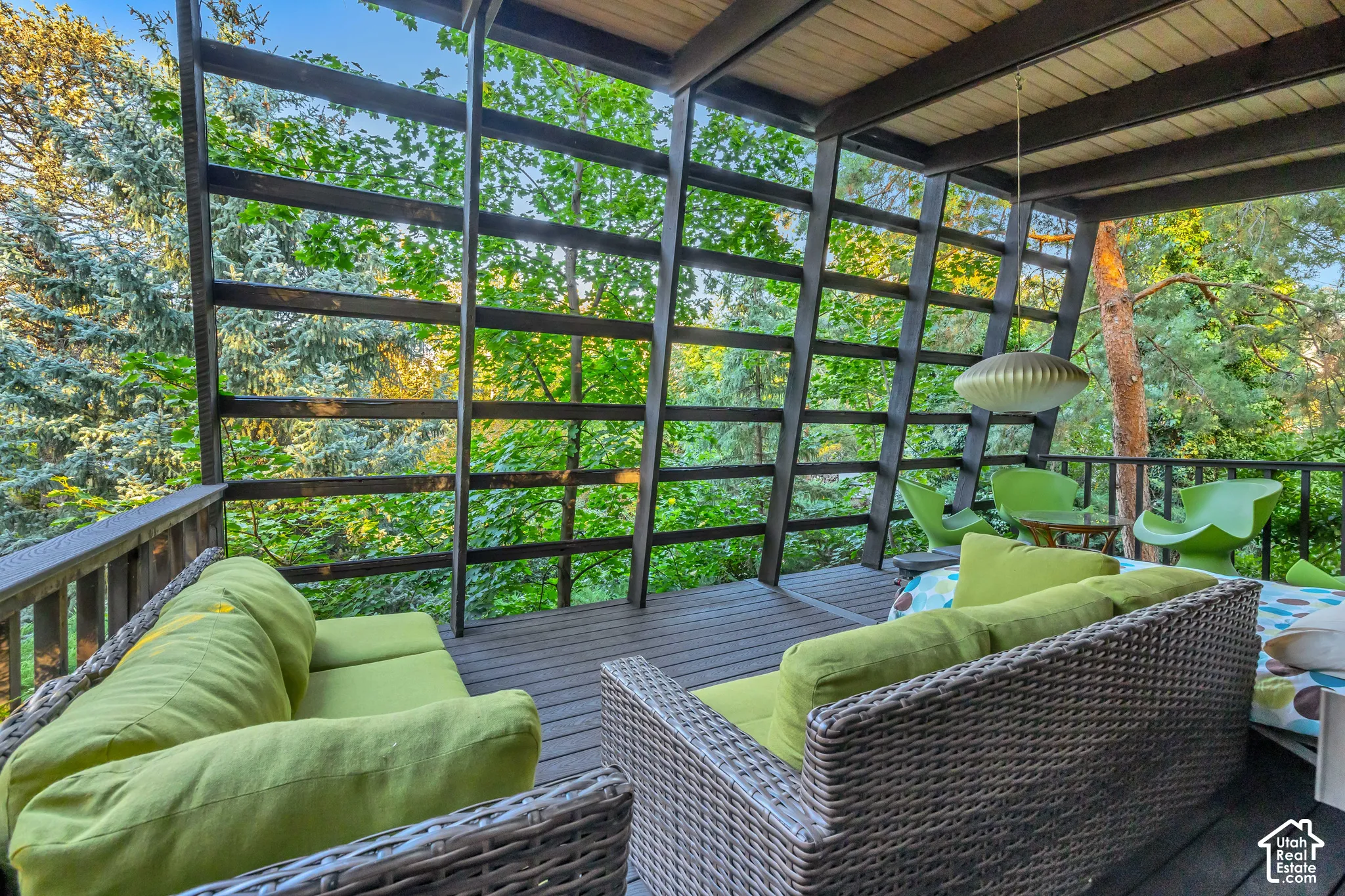 Expansive covered deck featuring wood-finish decking, dark-stained wood railing, and a slatted wood ceiling