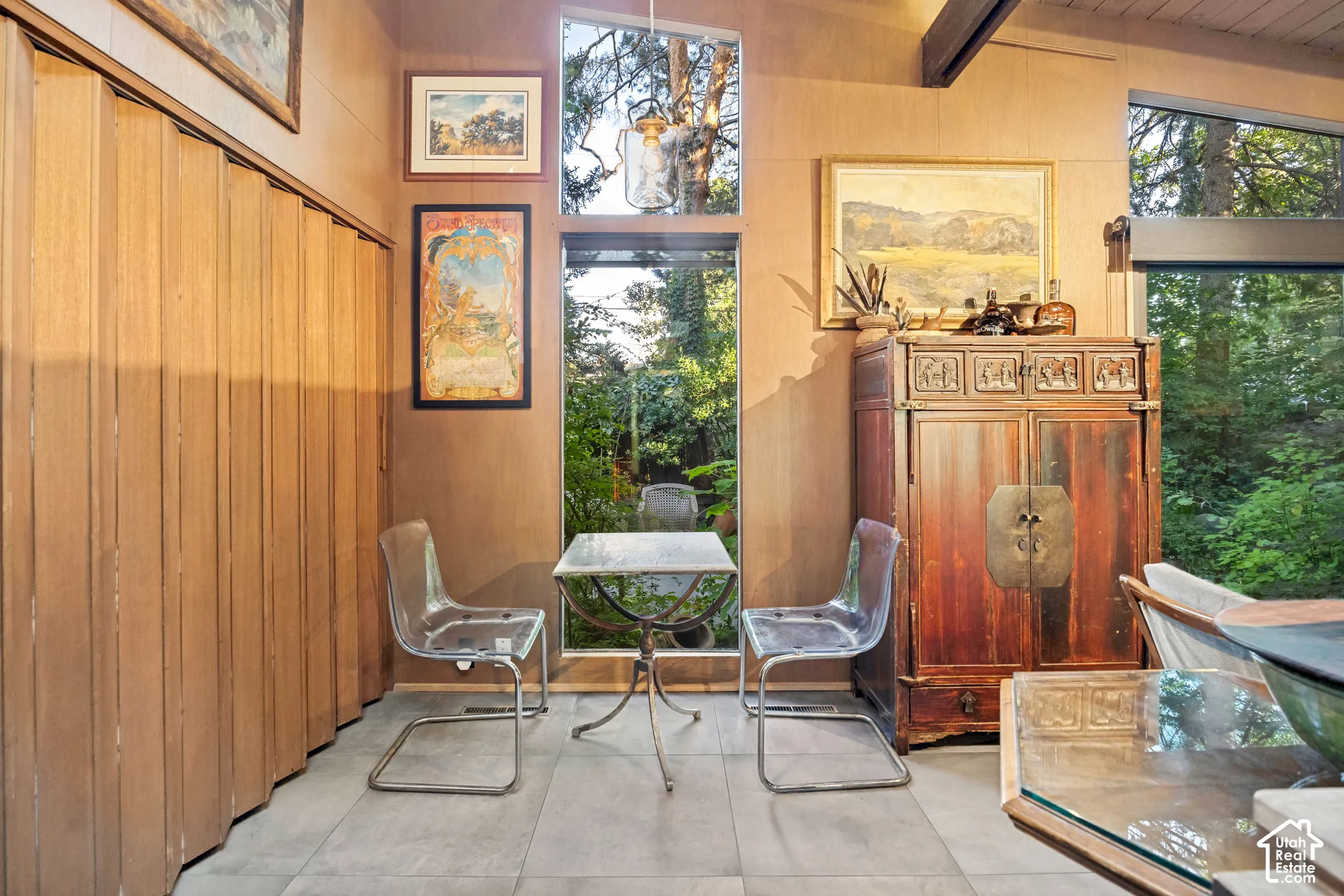 Floor-to-ceiling windows, wood-paneled walls, and a wood-finish ceiling beam