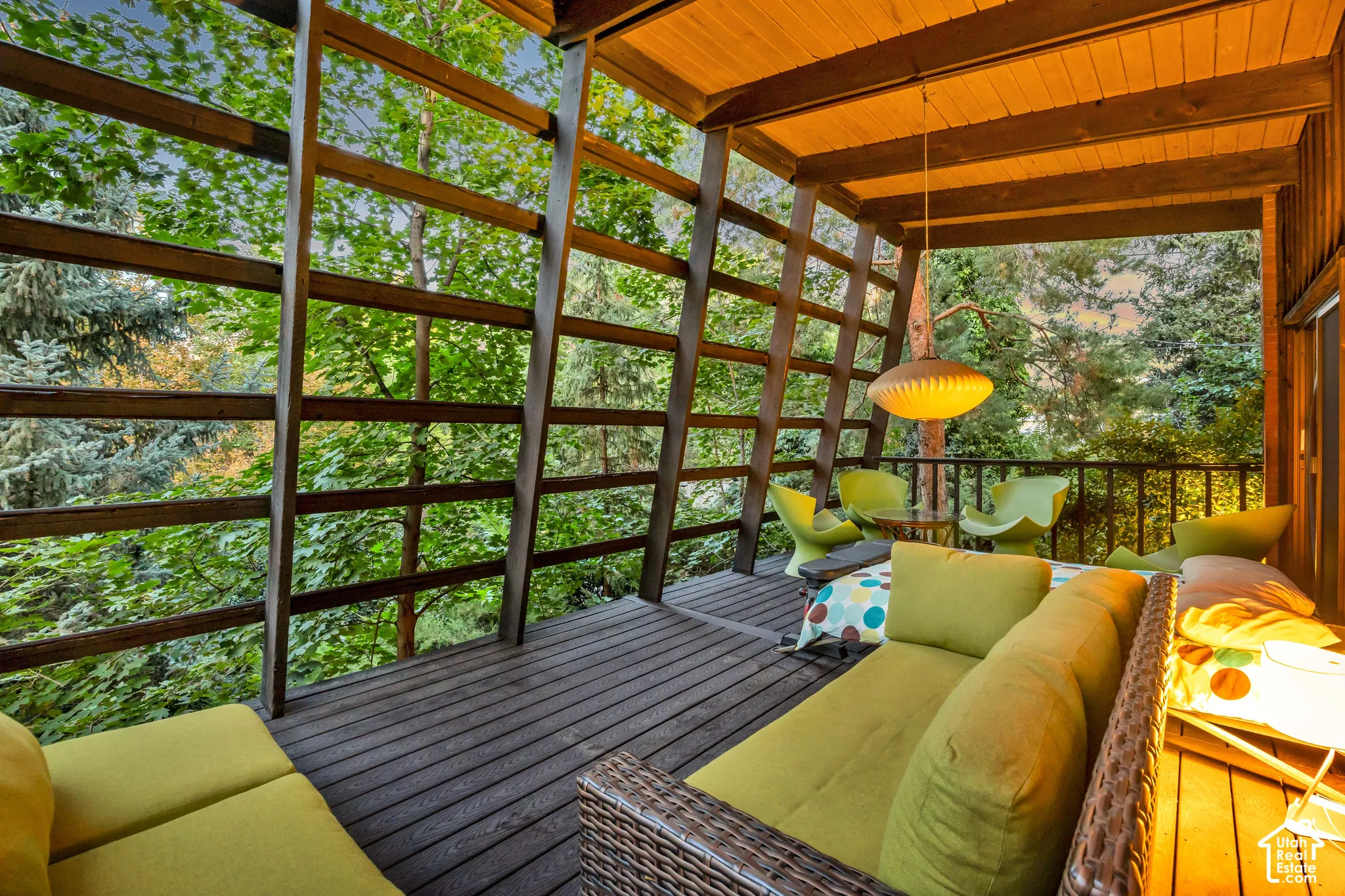 Expansive outdoor deck with wood-finish flooring, overhead lighting, and wood railing