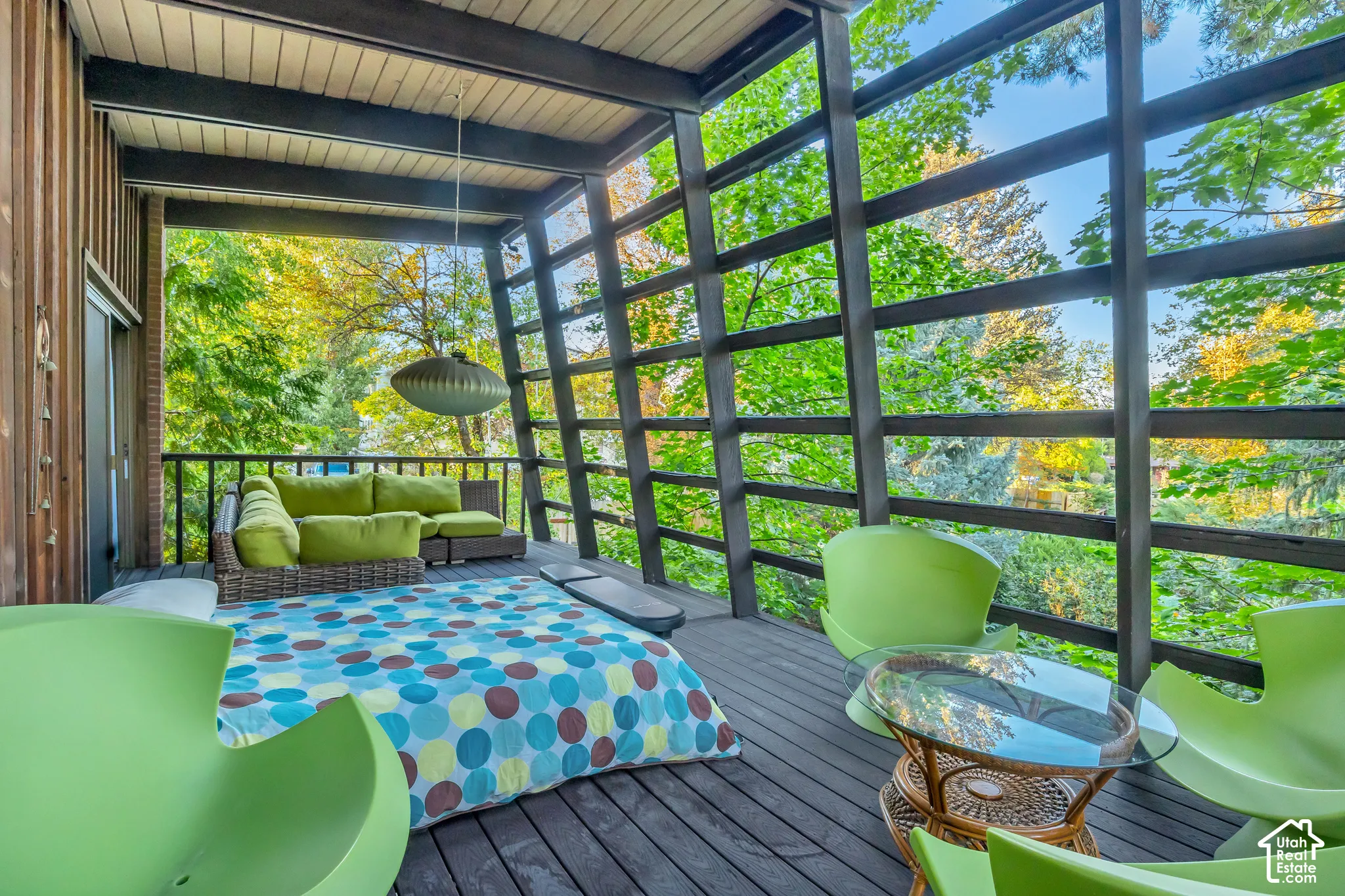 Expansive outdoor deck featuring dark wood-finish flooring, a wood plank ceiling, and a sliding glass door