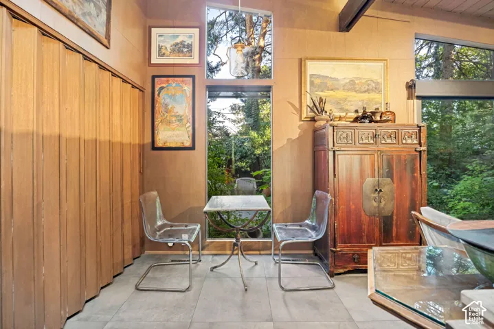 Floor-to-ceiling windows, wood-paneled walls, and a wood-finish ceiling beam