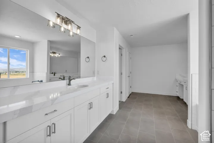 Expansive tiled primary bath with two separated vanity areas and sit down luxury with plenty of cabinetry topped with beautiful quartz countertops.  A very large fully tiled shower and soaker tub with tile surround with upgraded matte black hardware and f