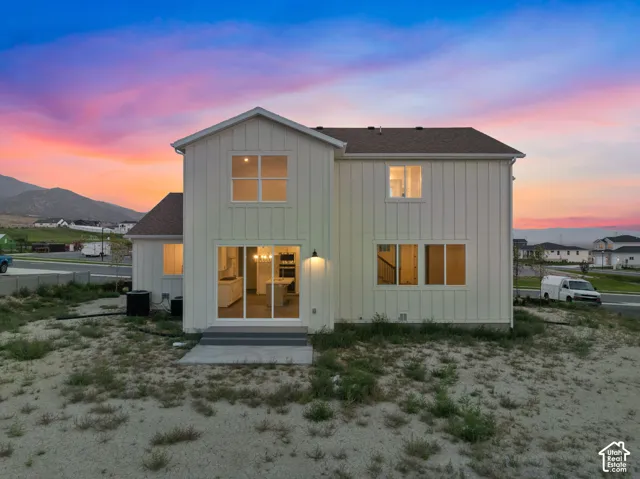 Back view of home at dusk.  This property is fully fenced on three sides of this generous half acre lot!