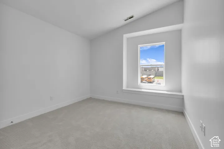 Vaulted bedroom with adorable window seat trimmed in a painted wood finish.