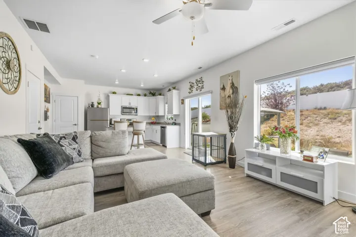 Open-concept living area featuring wood-finish flooring, recessed lighting, and a ceiling fan