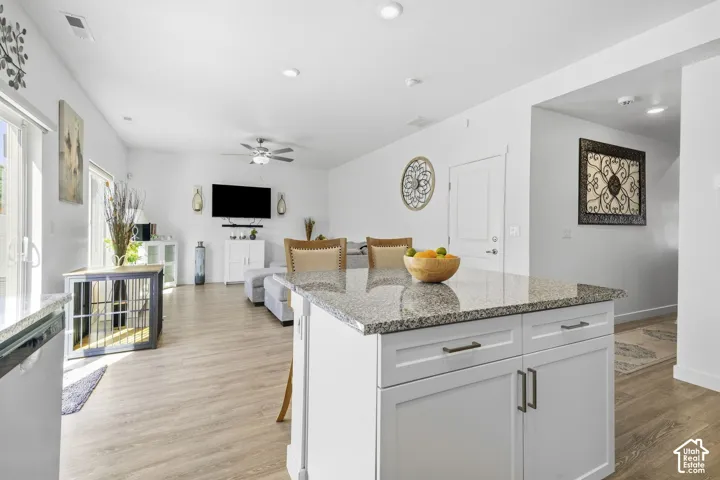 Kitchen island with granite-finish countertop and white shaker-style cabinetry