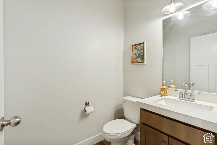Vanity with integrated sink, wood-finish cabinetry, and brushed nickel faucet