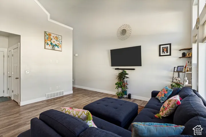 Spacious living area featuring wood-finish flooring, vaulted ceilings, and white trim throughout