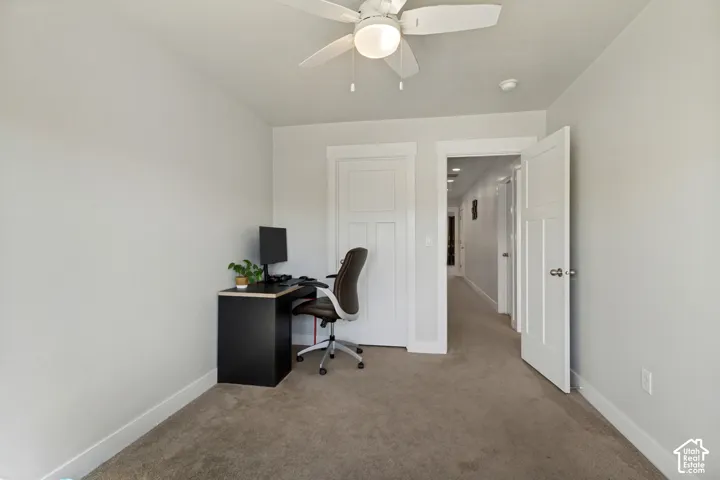 Carpeted flooring, white trim, overhead ceiling fan with light, and solid core doors