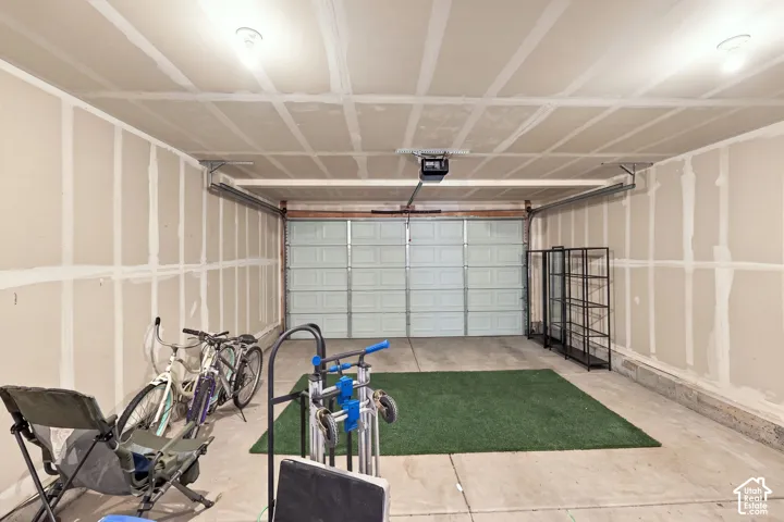 Attached garage with concrete flooring, automatic garage door opener, and overhead lighting