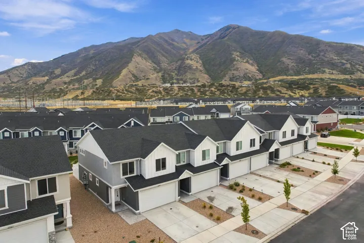 Contemporary townhomes featuring dark shingle roofs, white siding, and mountain backdrops