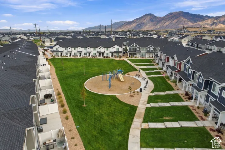 Community green space featuring a playground, manicured lawn, and paved walkways