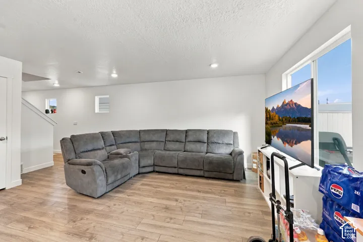 Wood-finish flooring with white walls and recessed ceiling lighting