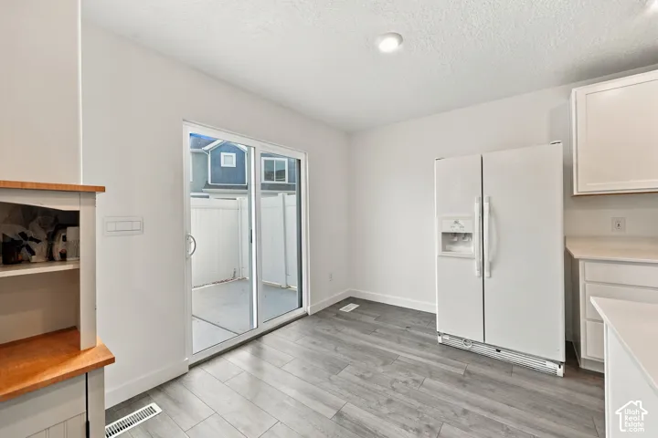 Sliding glass door, wood-finish flooring, recessed lighting, built-in shelving, white cabinetry