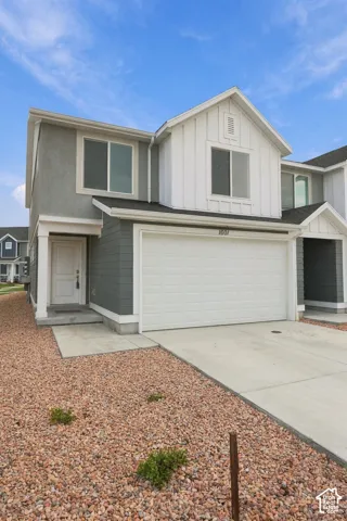Contemporary exterior with a two-car garage, concrete driveway, and low-maintenance rock landscaping