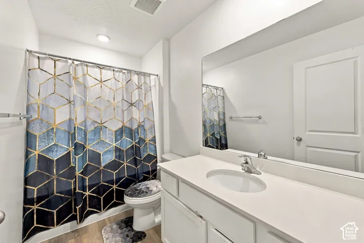 White vanity with an integrated sink, polished chrome faucet, and expansive wall-mounted mirror