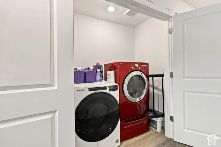 Dedicated laundry area with light wood-finish flooring