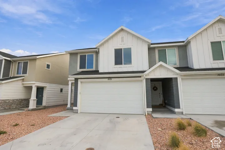 Contemporary facade with dual front-facing windows, attached garage, and a covered entry