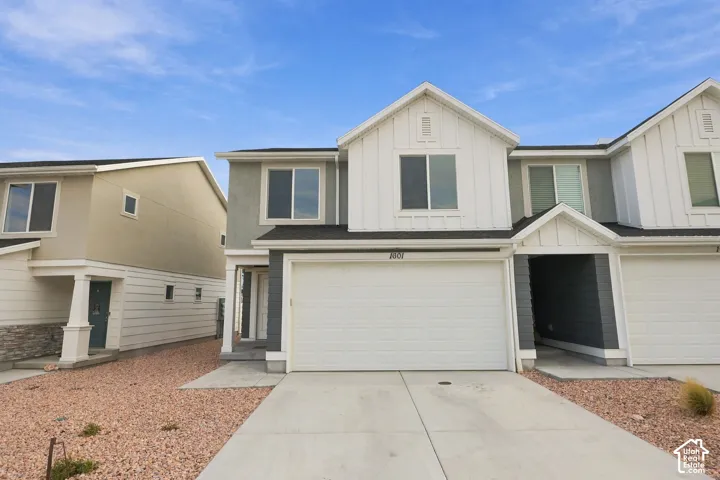 Contemporary facade with a two-car garage, board and batten accents, and a covered entry