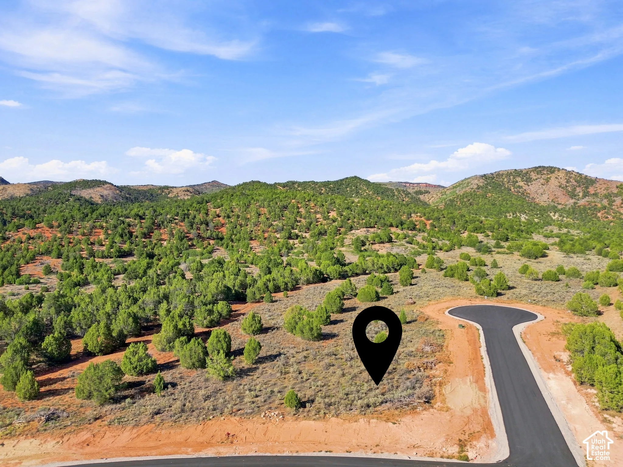 Paved cul-de-sac with natural landscaping, surrounded by wooded hillsides
